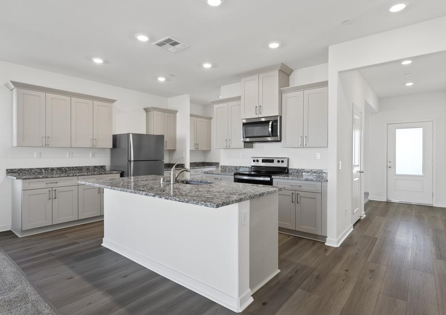 The chef ready kitchen has plank flooring and stainless steel appliances.
