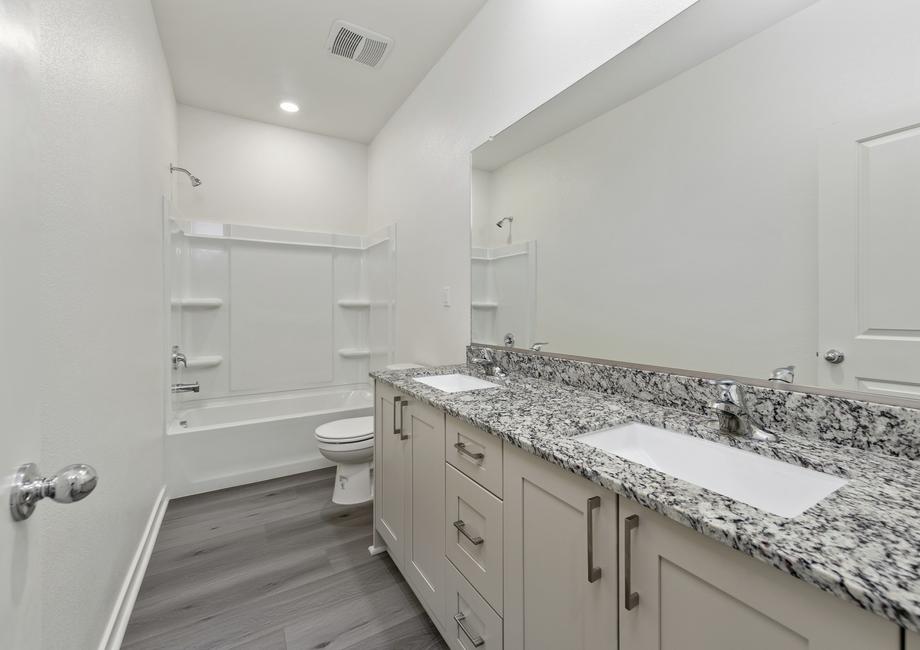 The secondary bathroom has a dual vanity and tub/shower combo.