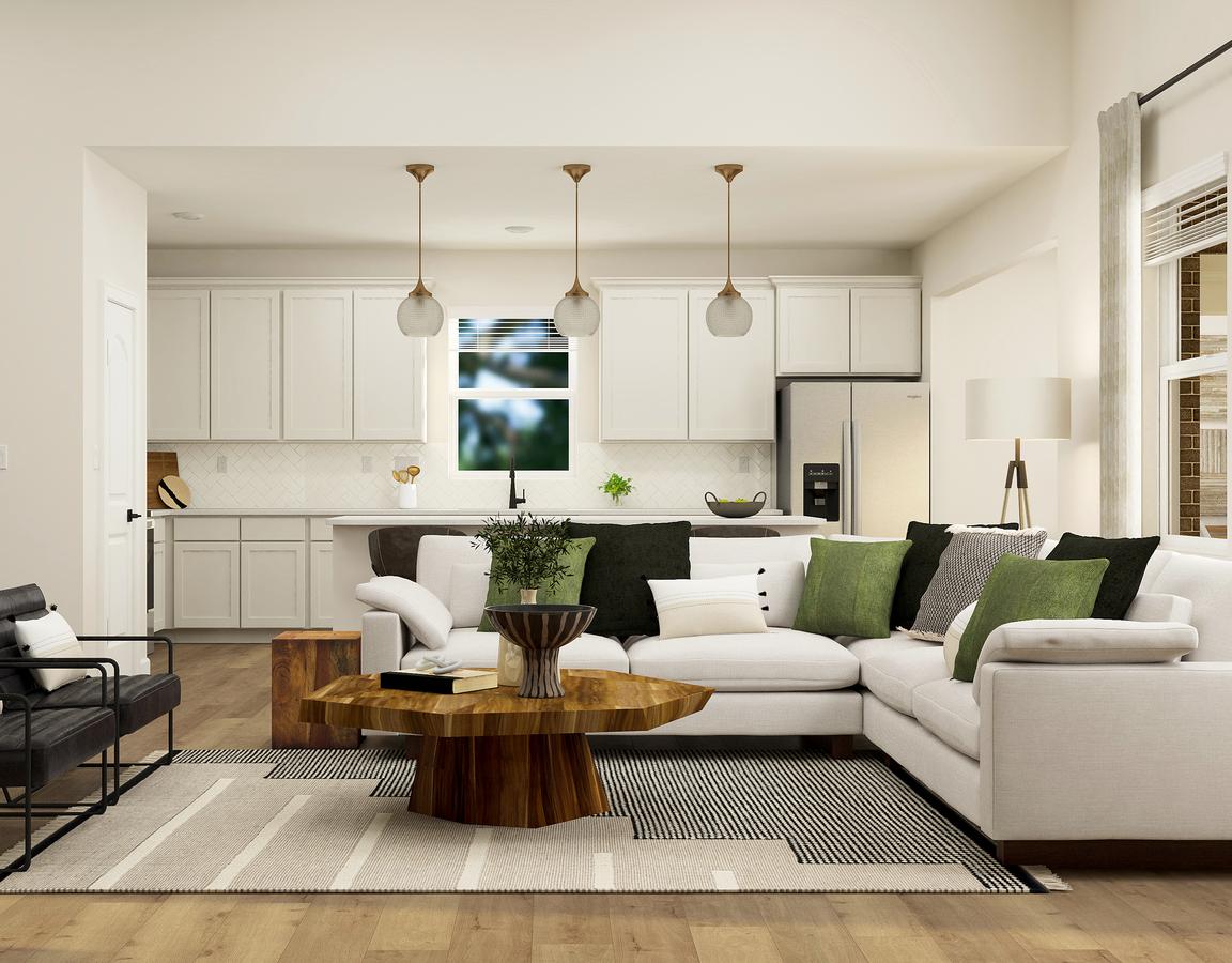 Rendering of dining room showing the kitchen with while cabinets in the back. The room is furnished with a large sectional couch and two side chairs.