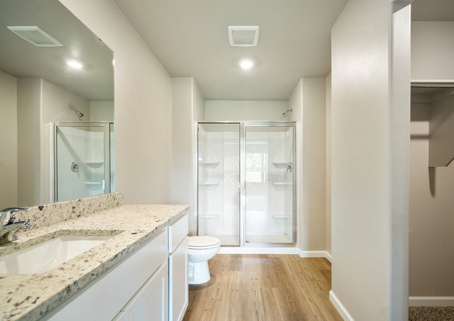 The master bathroom features a glass-enclosed shower and a spacious walk-in closet.