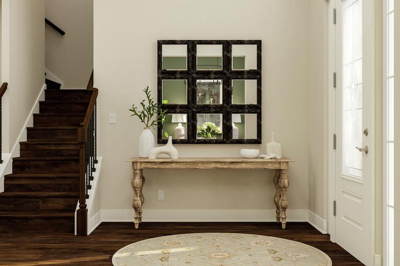 Rendering of entryway showing a white
  glass door on right, entryway table with dÃ©cor center, and dark wood look
  stairs on left.