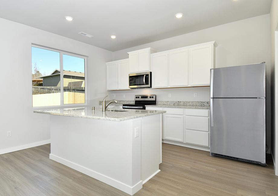 The kitchen has stainless steel appliances and white cabinets.