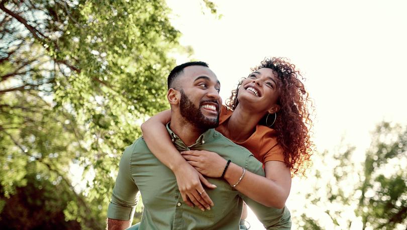 Couple outside with trees in background.