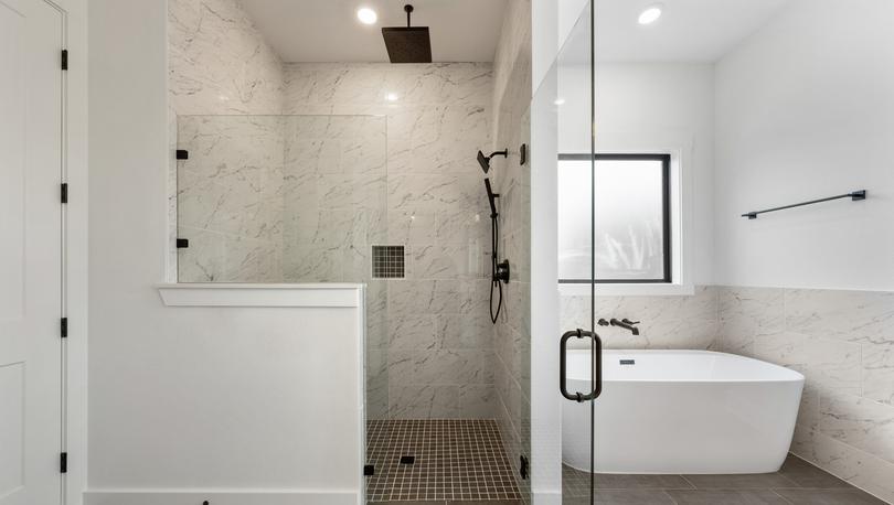 The gorgeous master bathroom has a large glass, walk-in shower and tub.