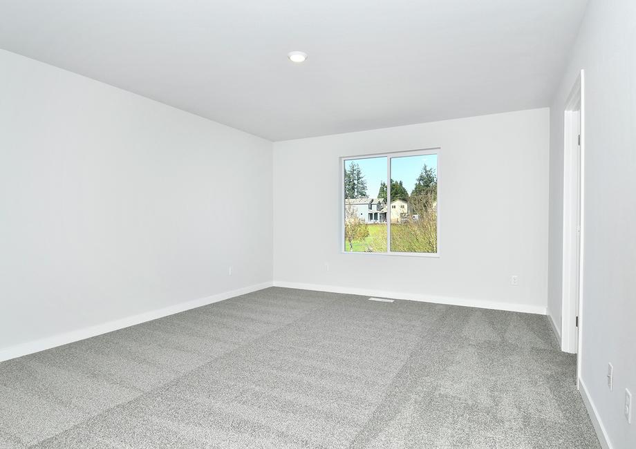 The master bedroom has a large window and carpet.