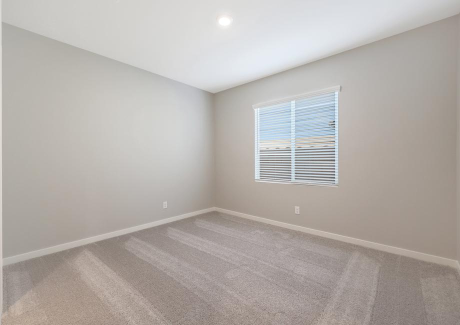 Guest bedroom with large windows and plush carpet.