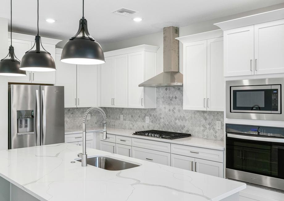 The stunning kitchen is fully loaded with stainless steel appliances.