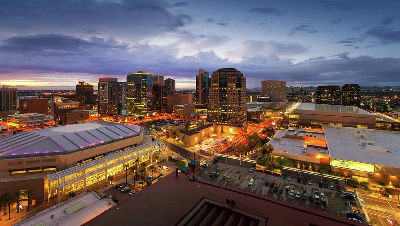 Phoenix, Arizona downtown arenas at night showing lit streets, tall office buildings, and cloudy skies