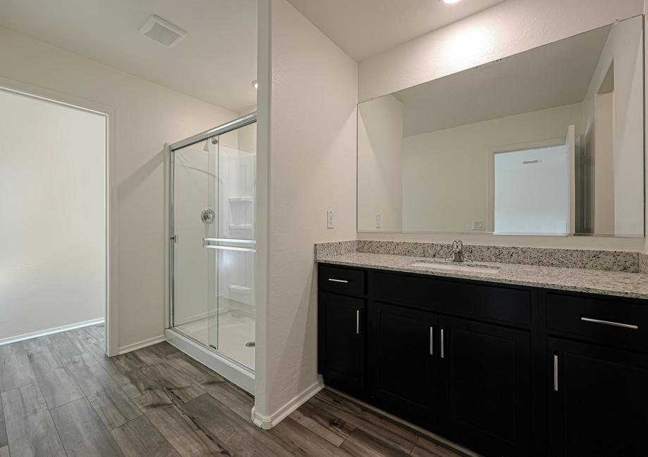 The master bath has a spacious, glass-enclosed shower and beautiful granite countertops.