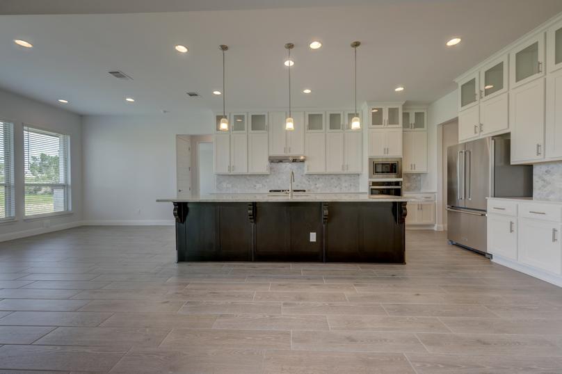 Fully-equipped kitchen with designer finishes, including oversized cabinetry, a large island, and stainless appliances.