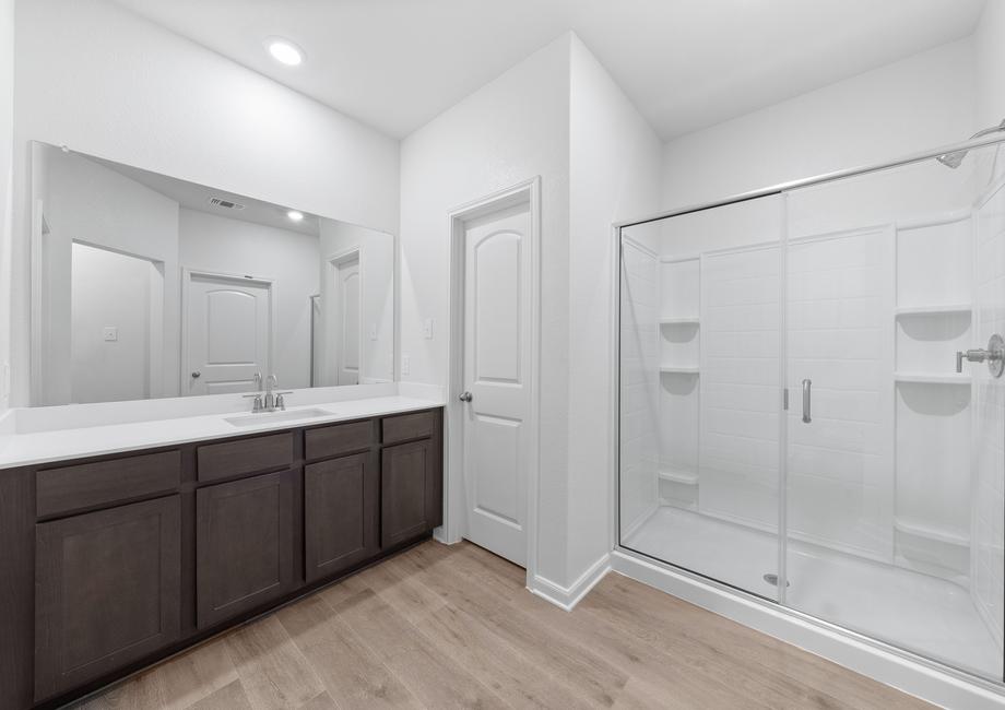 The master bathroom has a large vanity space and glass walk-in shower.