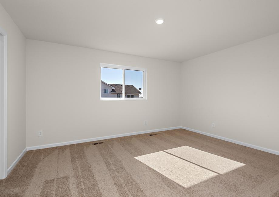 The master bedroom is spacious with a large window.