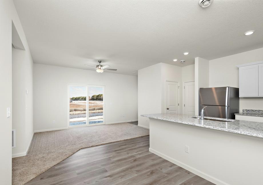 The family room is off of the kitchen and has a ceiling fan.