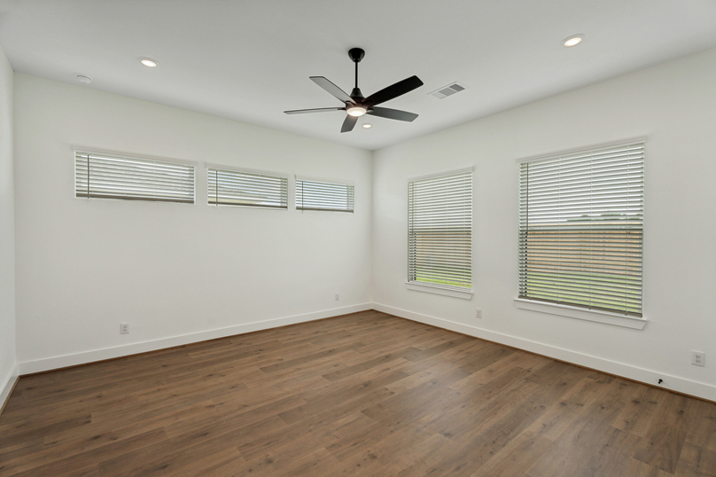 Primary bedroom with large windows.