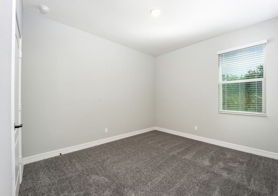 The spare bedroom is spacious with a large window