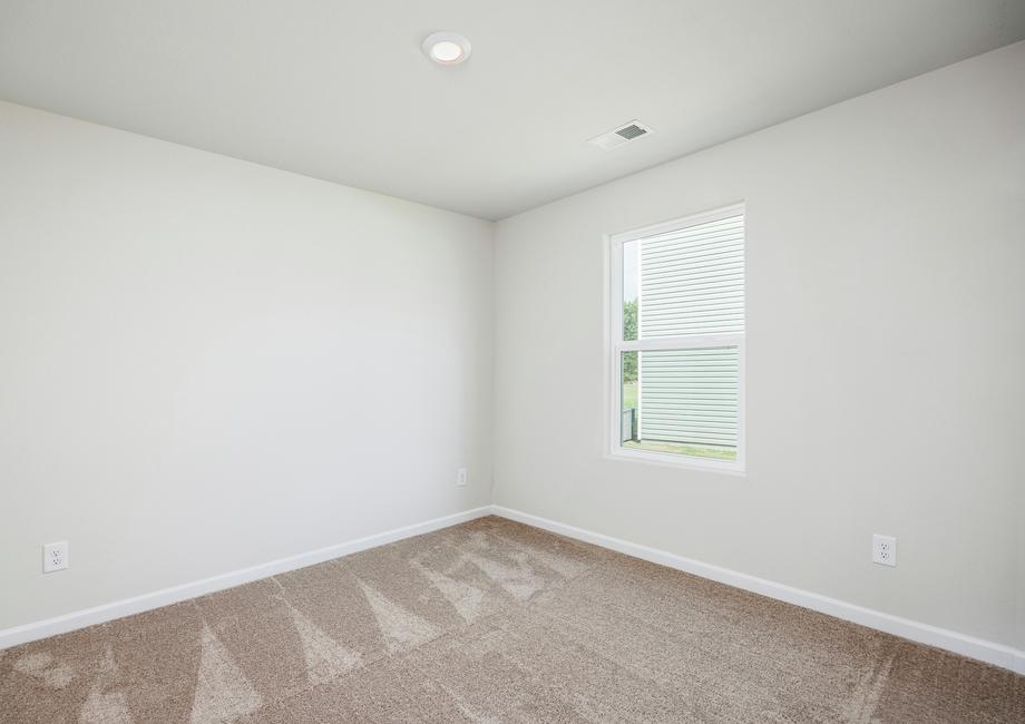 Secondary bedroom with carpet and a window.