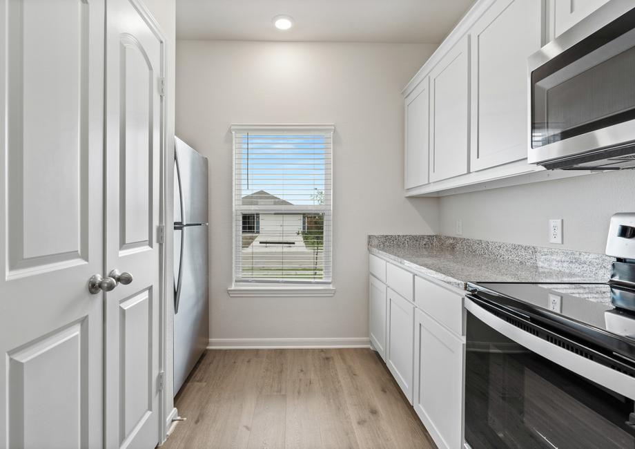 The kitchen of the Driftwood has beautiful white wood cabinets.