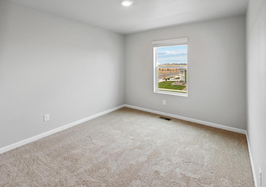 Secondary bedroom with a window and recessed lighting.