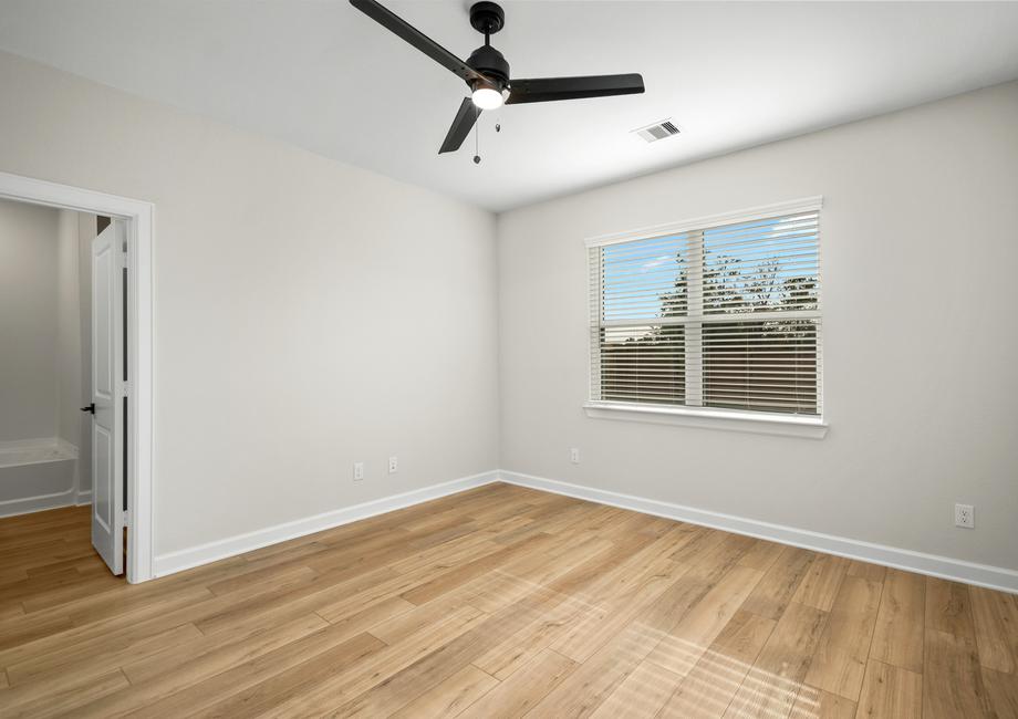 A large window in the master bedroom looks out to the backyard