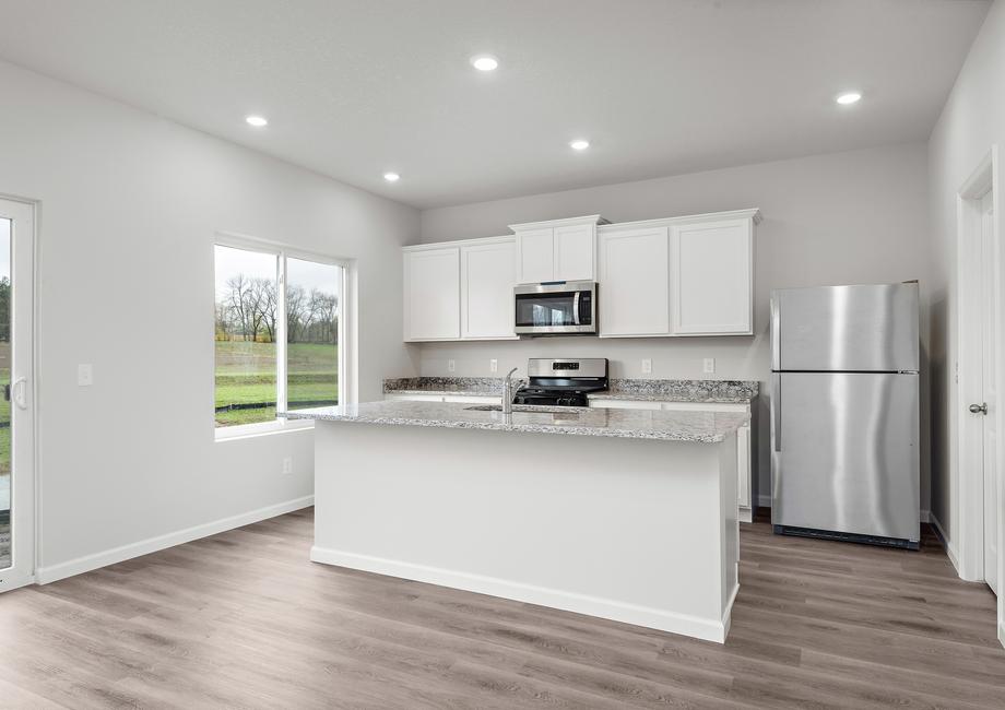 The kitchen has stainless steel appliances and plank flooring.