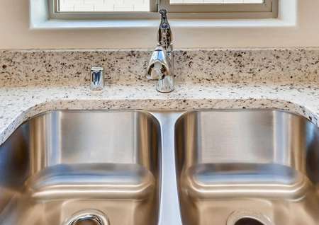 Boulder kitchen with modern fixture, undermount double basin sink, and spotted granite stone counters