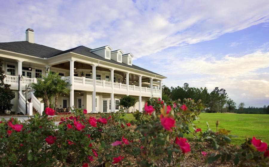 The Southern Hills Clubhouse with flowers and a blue sky.