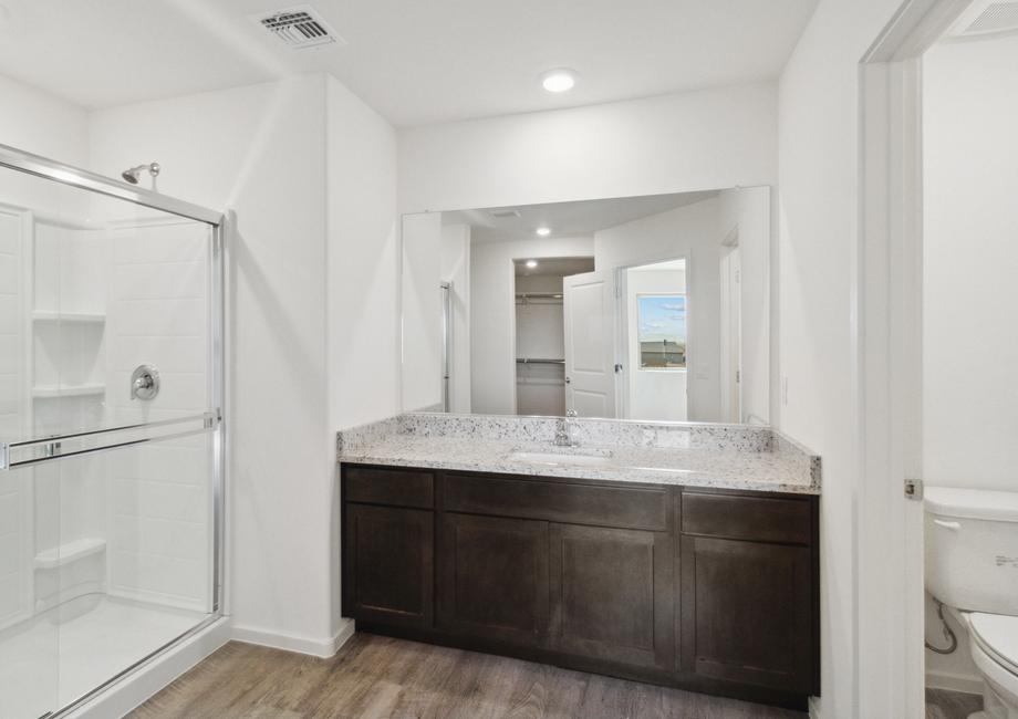 Attached master bathroom with a walk-in shower and private restroom.