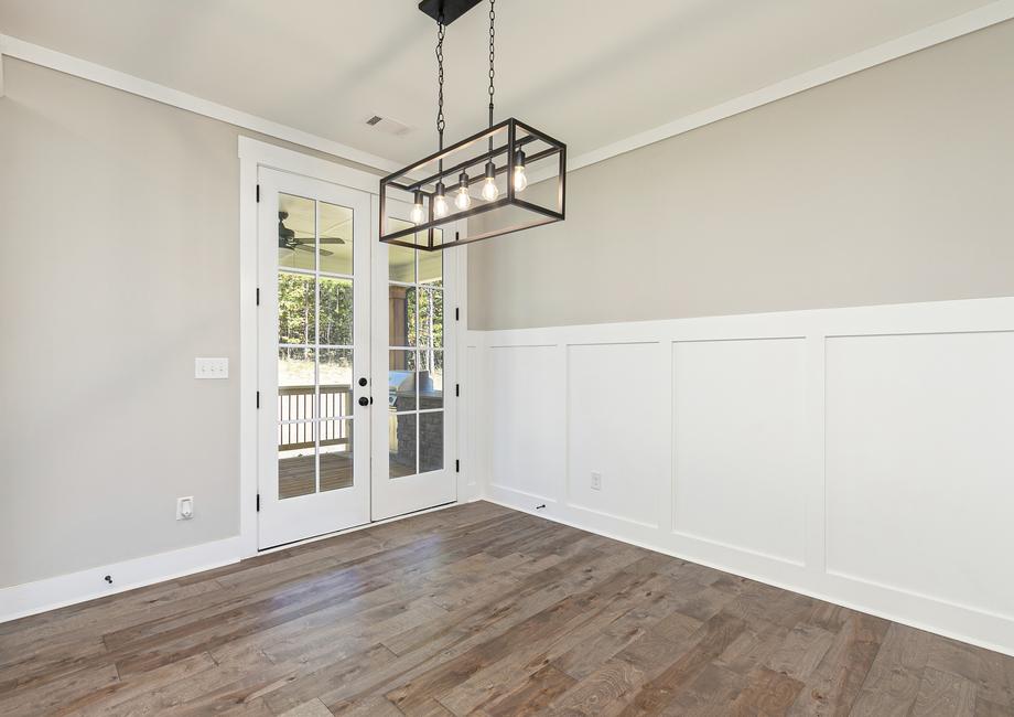 Dining area with pendant and wood floor.