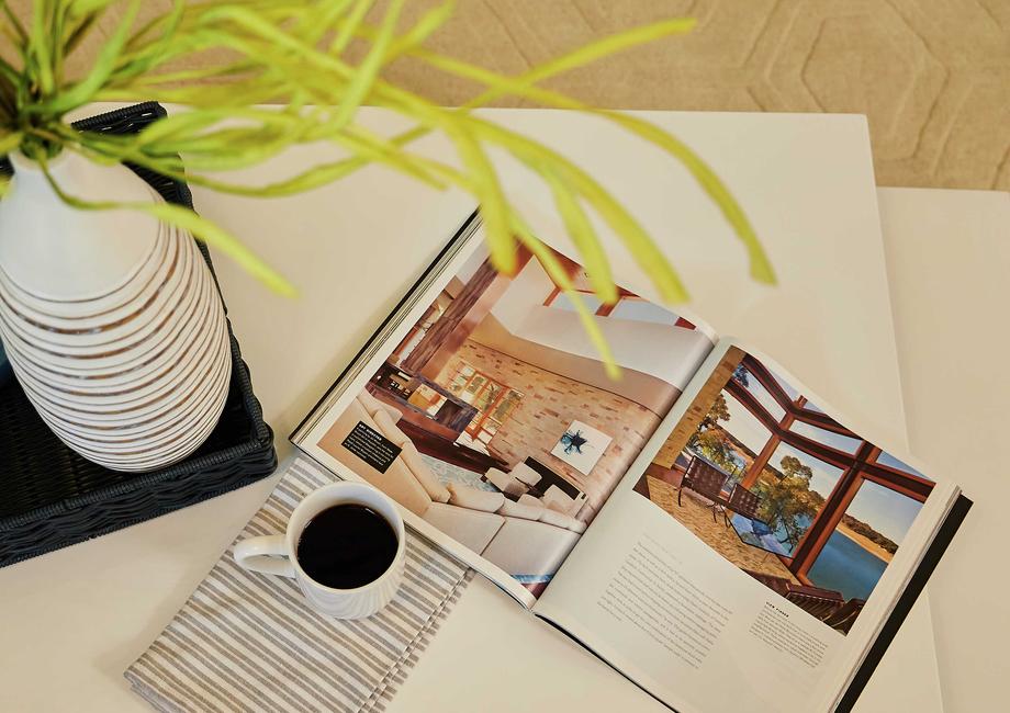 Living room with coffee table, cup of coffee, and open book.