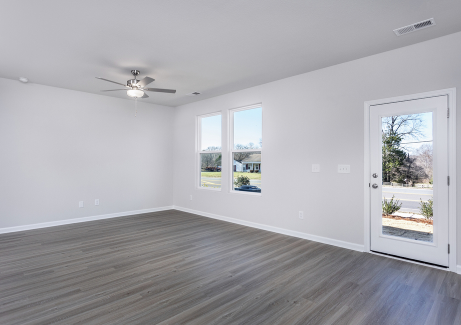The living room has lots of space and windows that let in lots of natural light