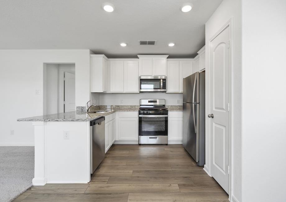Upgraded kitchen features stainless appliances and granite countertops.