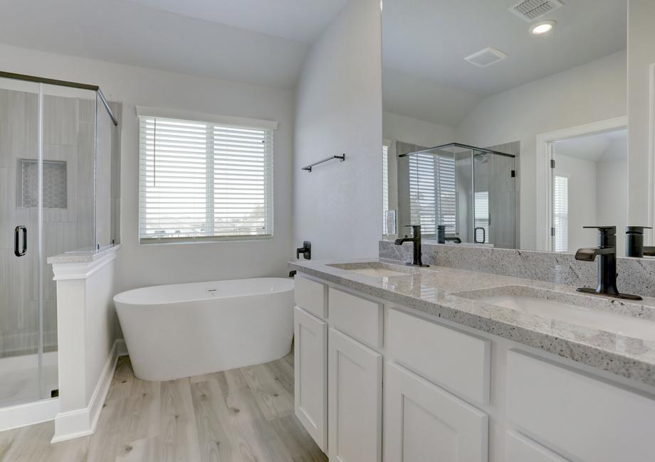 Master bath with a soaking tub, walk-in shower and two sinks. 