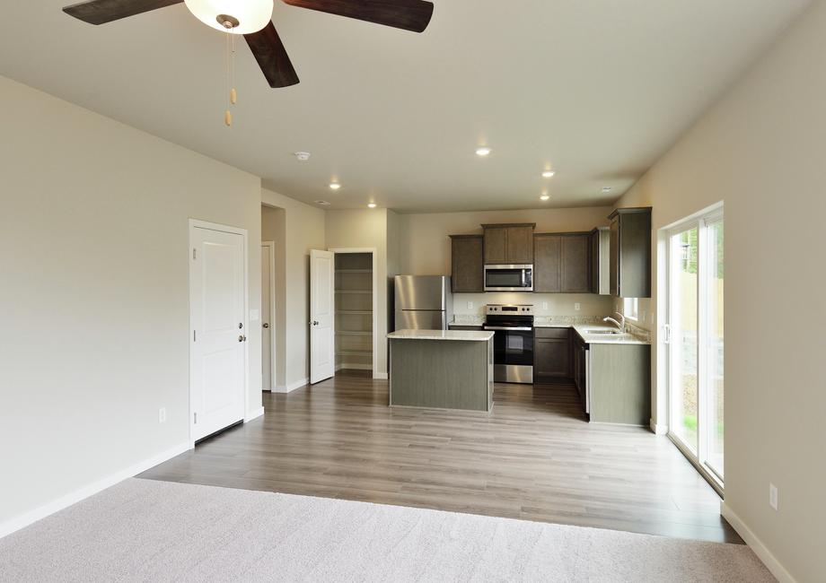 The kitchen has stainless steel appliances and plank flooring.