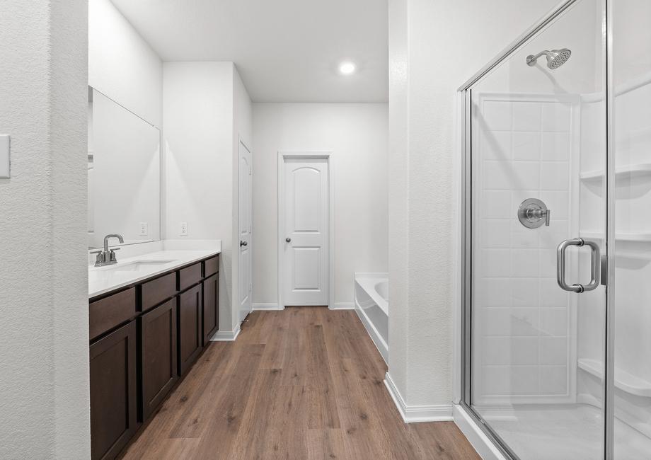 The master bathroom of the Cypress has a glass walk-in shower and a garden tub.