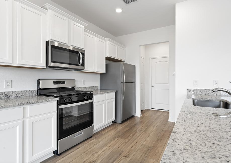 Chef-ready kitchen with stainless steel appliances, granite countertops, and white cabinetry.