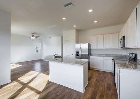 Open-concept kitchen with installed stainless steel appliances and granite countertops.