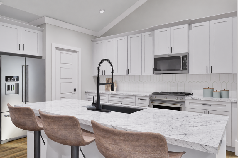 Modern kitchen in the Burton home featuring stainless steel appliances, island, and ample cabinetry.