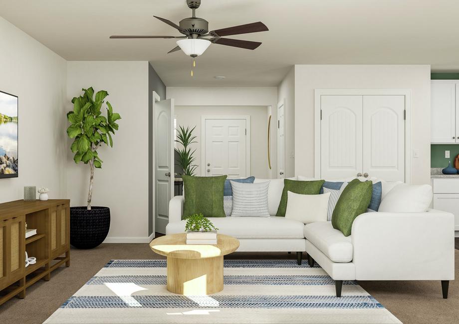 Rendering of the living room looking
  towards the front door. The room is furnished with a white sectional, round
  coffee table, blue-and-white striped rug and a media center.