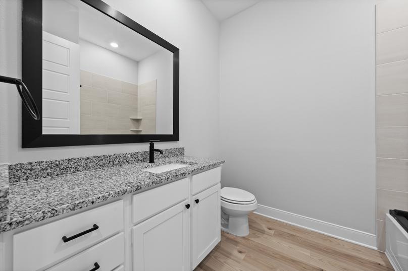 Enjoy granite countertops and framed mirrors in the secondary bathrooms.