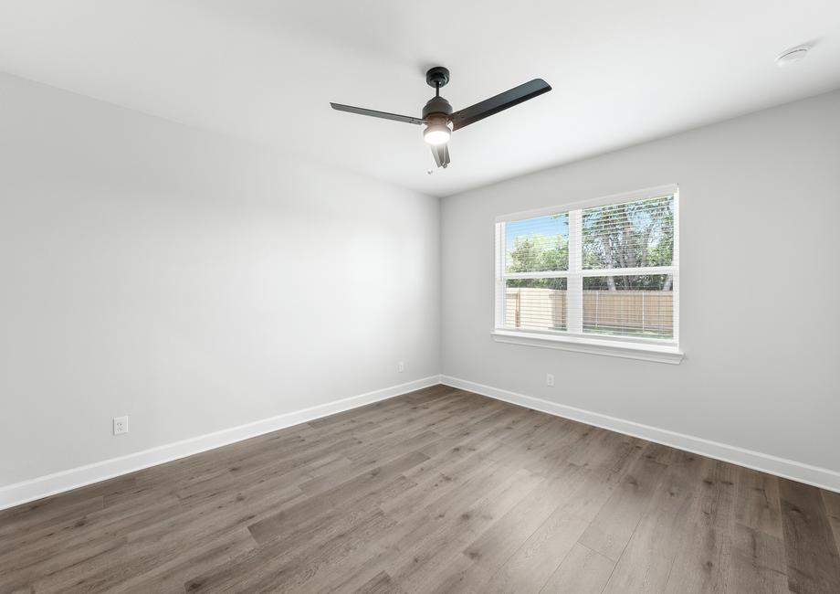 The master bedroom of the Blanco is spacious and has a large window letting great, natural light and backyard views.