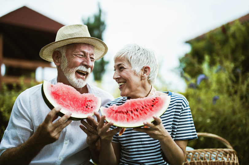 Mature couple eating watermelon.