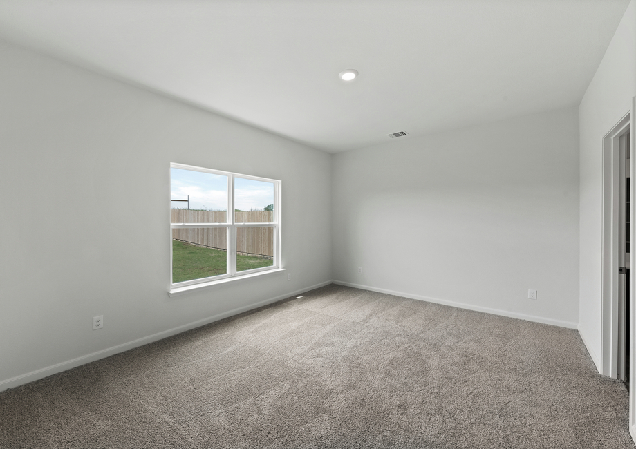 The master bedroom of the Driftwood has a large window that lets in great natural light and backyard views.