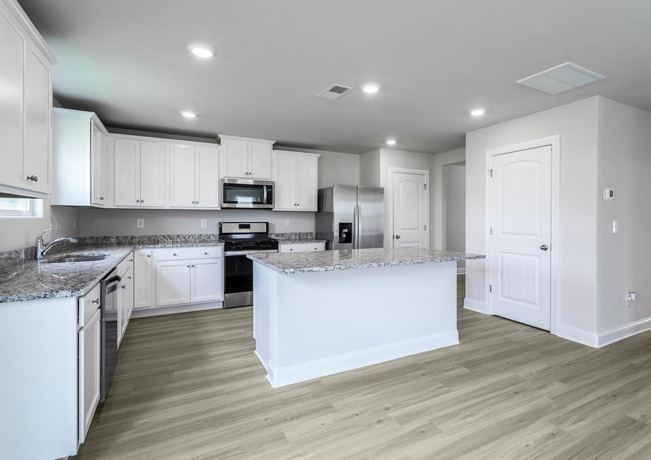 Chef ready kitchen with a large granite island and stainless steel appliances.