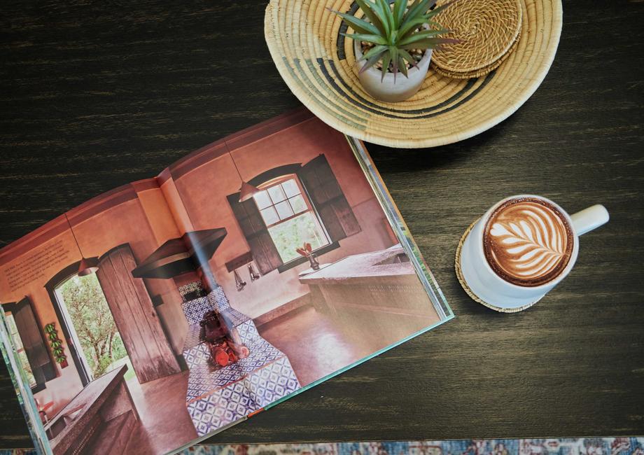 Stock photo detail shot of a wooden table with a cup of coffee and a magazine.