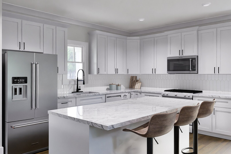 Bright kitchen with white cabinetry, granite countertops, stainless steel appliances, and island with barstool seating.