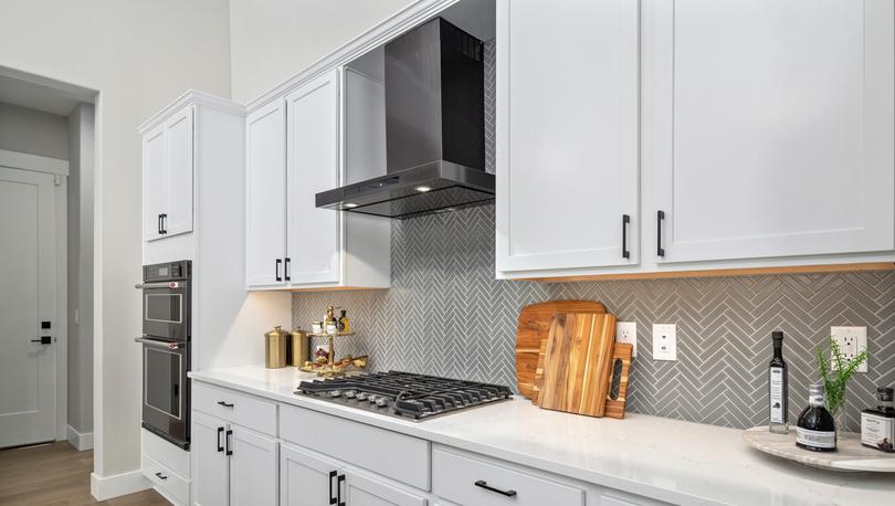 Kitchen with white cabinets and quartz countertops.