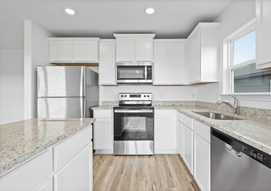 Granite countertops and stainless steel appliances fill the kitchen