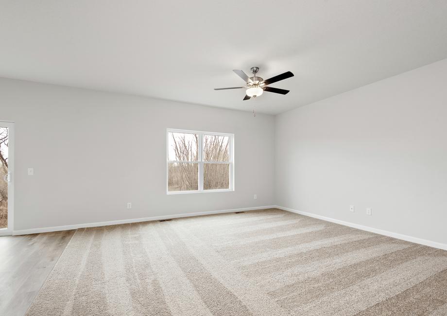 The family room is spacious with carpet and a ceiling fan.