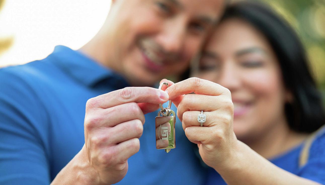 Happy customers holding the keys to their new LGI home.