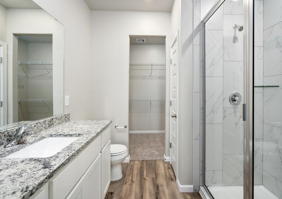 The master bathroom has a large glass, walk-in shower.